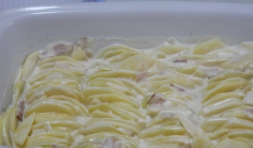 1. Этап. Картофельный гратен с сыром и беконом: Выложить плотно картофель в посуду для запекания. Сверху залить оставшейся сырной массой.