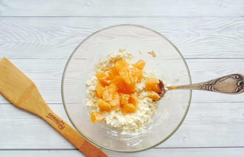 1. Этап. Сырники с мандаринами: Мандарины вымойте, очистите. Разберите на дольки. Каждую дольку разрежьте на 2-3 части. Переложите в миску с остальными ингредиентами.