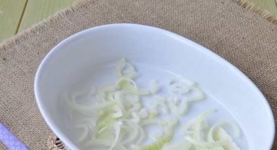 1. Этап. Лосось под соусом в духовке: Лук почистите и нашинкуйте полукольцами. В форму для запекания влейте масло и уложите половину лука.