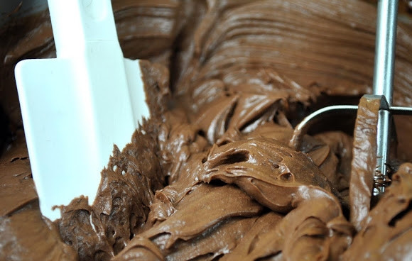 1. Этап. Мокрый торт: А пока остывает торт, приготовьте ганаш. Поломайте шоколадку и залейте горячими сливками (но не дайте им закипеть). В течение минут вы увидите, что шоколад тает, размешайте, добавьте масло и взбейте миксером до увеличения в размере.