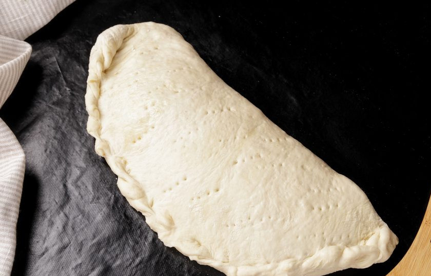 1. Этап. Пицца Кальцоне: Накройте начинку второй половиной теста и хорошо скрепите края любым удобным образом. Аналогично сформируйте закрытую пиццу из второго кусочка теста. Верх теста можно смазать яичным желтком, растительным маслом или небольшим количеством томатного соуса.