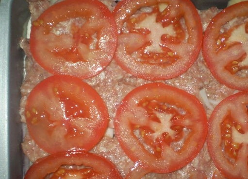 1. Этап. Картофельная запеканка с майонезом: 6. Теперь нарежьте кружками помидоры. Выложите их поверх мясного слоя.