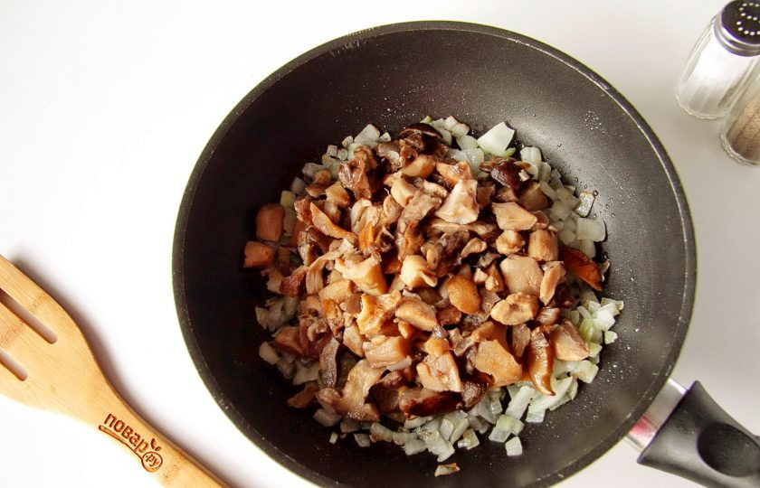 1. Этап. Заливной пирог с курицей и грибами: Обжарьте лук до мягкости и добавьте грибы. У меня лесные, уже заранее отваренные и нарезанные, но можно взять любые другие. Готовим помешивая до испарения жидкости.