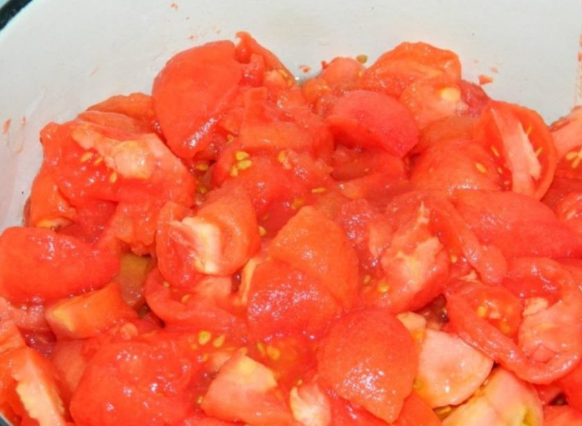 1. Этап. Баклажаны в томатах на зиму: Помидоры залейте кипятком, дайте постоять пару минут. Затем кипяток слейте, окуните помидоры в холодную воду и снимите кожицу. Нарежьте помидоры и сложите в кастрюлю.