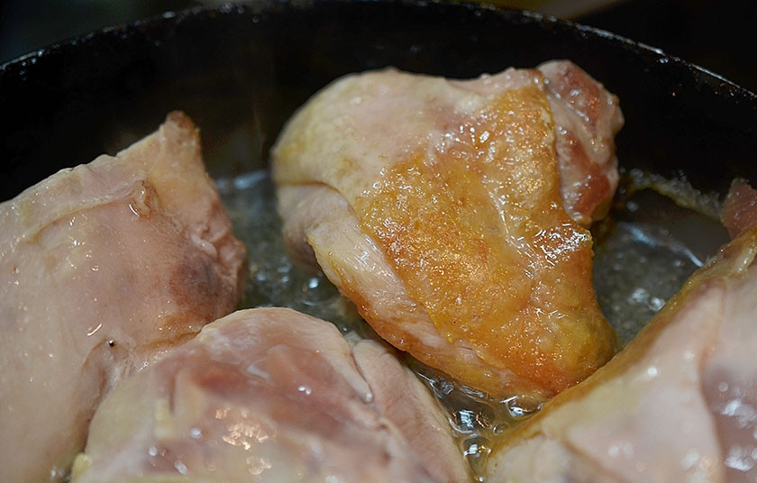 1. Этап. Курица в сидре с яблоками: Разогрейте масло и обжарьте кусочки курицы до хрустящей корочки.