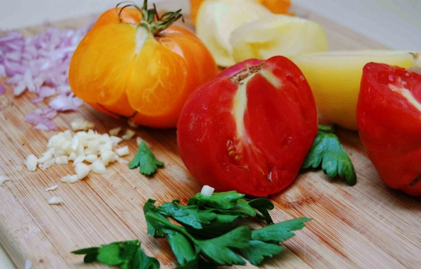 1. Этап. Палтус на сковороде: Для начала измельчите лук, чеснок, зелень. Порежьте помидоры.