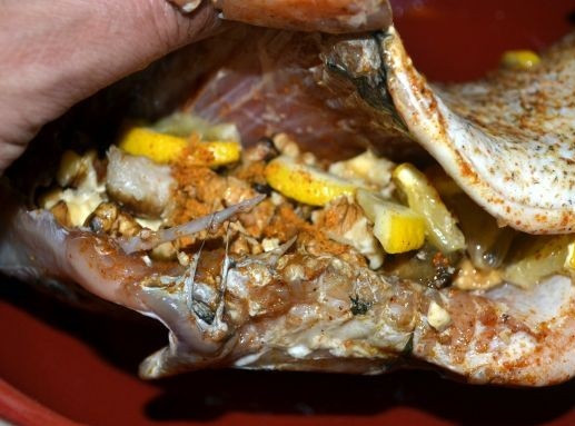 1. Этап. Белая рыба, запеченная в духовке: 5. Измельчить немного орехи и грибы. Добавить 3-4 ломтика лимона и поместить все это в брюшко. Из оставшегося лимона выжать сок и соединить с растительным маслом. Полить сверху рыбку и убрать в холодильник на 30-45 минут.