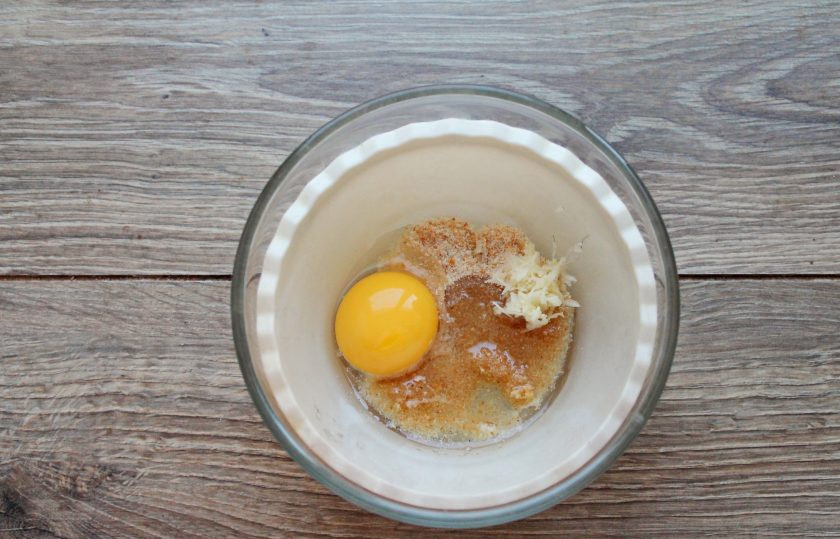 1. Этап. Эскалоп из индейки в духовке: В миску насыпьте панировочные сухари, остальное растительное масло, добавьте тертый чеснок и желток, белок нам не понадобится. Все хорошо перемешайте.