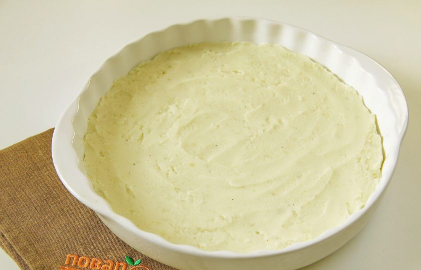 1. Этап. Яйца Пармантье: Форму для запекания смажьте маслом и выложите картофельное пюре. Разровняйте пюре ложкой.