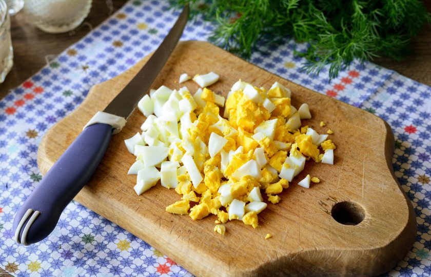 1. Этап. Теплый салат с баклажанами: Куриные яйца сварите вкрутую и почистите. Нарежьте кубиками для салата.