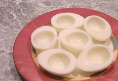 1. Этап. Яйца по-немецки: 4. Сварившиеся яйца выкладываем на тарелку, даем остыть. Затем очищаем от скорлупы, разрезаем пополам и аккуратно выбираем ложкой желтки.