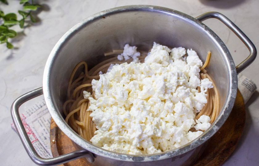 1. Этап. Спагетти с творогом и яблоком: Слейте воду или откиньте спагетти на сито и верните в кастрюлю. Сразу к пасте добавьте творог.
