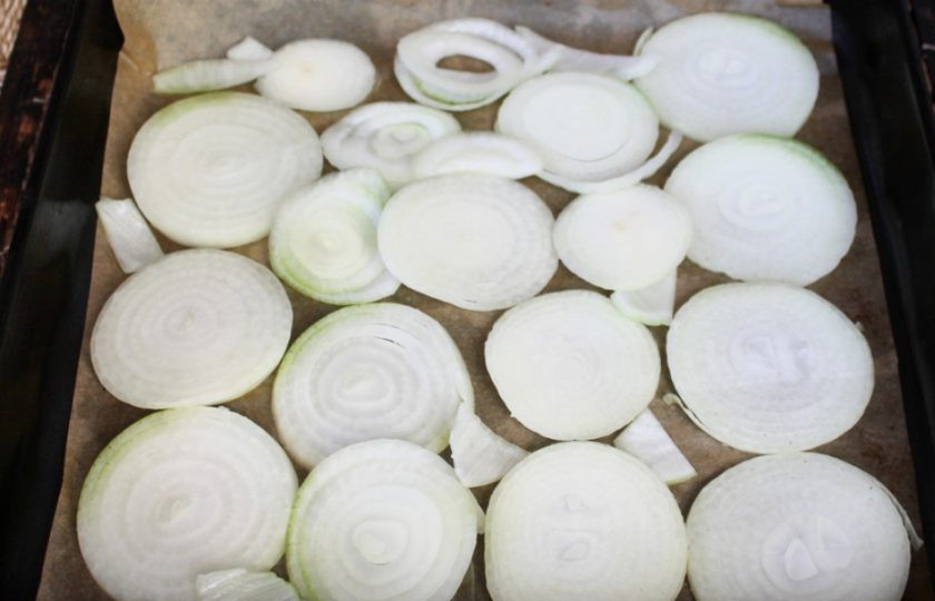 1. Этап. Свиная корейка с розмарином и чесноком в духовке: На противень выкладываем нарезанный кольцами лук.