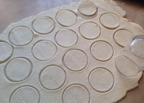 1. Этап. Печенье Гусиные лапки с творогом: Посыпаем стол небольшим количеством муки и раскатываем тесто в тонкий пласт. Толщина - примерно 3 мм. Стаканом вырезаем кружочки.