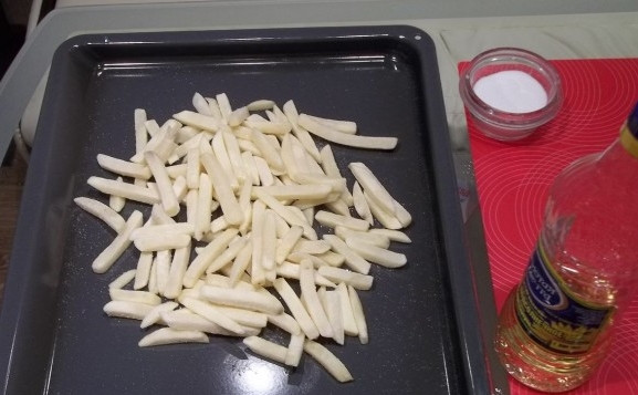 1. Этап. Купаты с картошкой в духовке: 1. Картошку моем, чистим, нарезаем брусочками. Посыпаем специями и заливаем маслом. Перемешаем руками, чтобы и масло, и специи равномерно распределились. Однако для экономии времени можно купить просто готовый полуфабрикат в магазине.