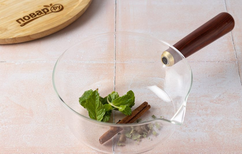 1. Этап. Брусничный сбитень: Переложите все пряности и веточку мяты в кастрюлю или сотейник. Лавровый лист поломайте на мелкие кусочки.