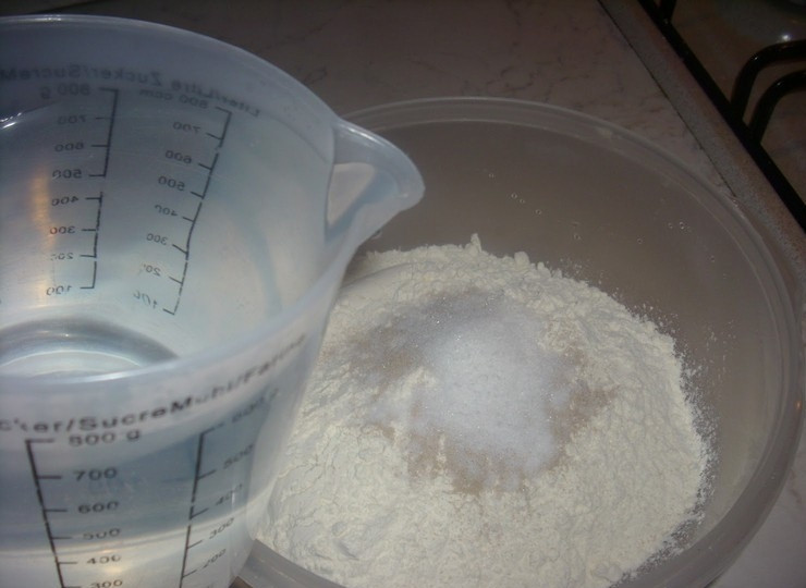 1. Этап. Пончики в сахаре: 2. Влейте теплую воду и хорошо перемешайте.