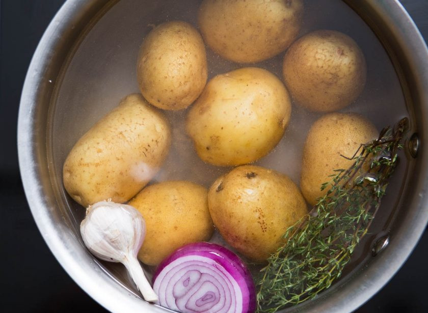 1. Этап. Салат с консервированным тунцом и яйцом: 2. Картошку мою и заливаю водой, добавляю 1 луковицу, тимьян и 4 зубчика чеснока, насыпаю столовую ложку соли, варю до готовности.