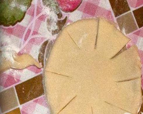 1. Этап. Творожные плюшки Бешеная тыква: 3. Приблизительно в миллиметра три раскатываем тесто, примерно размером с ладонь вырезаем круги. Чтобы тесто легче лепилось, немного его увлажняем. По кругу теста делаем небольшие насечки.