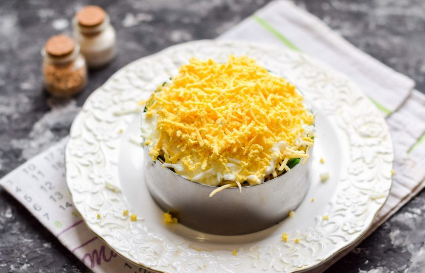 1. Этап. Салат Мимоза с красной рыбой: Завершающий слой — натертый на мелкой терке куриный желток. Оставьте салат на несколько часов для пропитки и подавайте к столу.