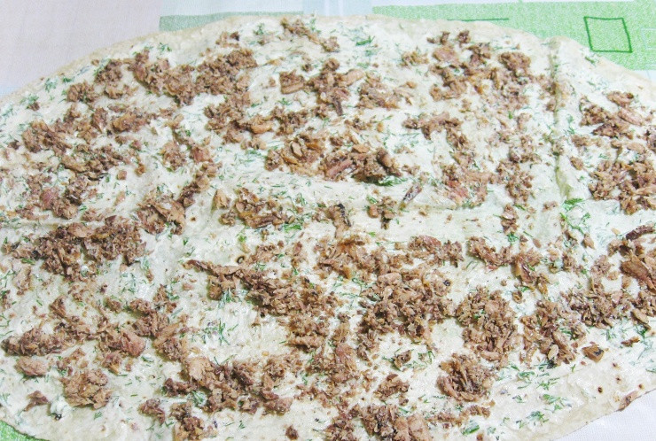 1. Этап. Рулет из лаваша с консервированной рыбой: Поверх майонеза выкладываем рыбную консерву, распределяем ее по всему лавашу.