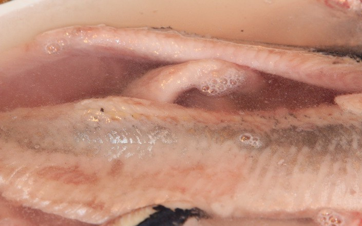 1. Этап. Сельдь в горчичной заливке: Прежде всего, селедку необходимо разморозить, затем отделить филе от хребта, удалить кости и кожицу. Выкладываем ее в глубокую миску, заливаем литром воды, добавляем столовую ложку соли, перемешиваем. Оставляем селедку в этом рассоле примерно на 2 часа.