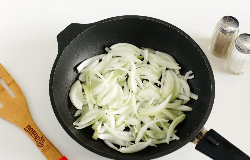 1. Этап. Кальмары по-гречески: В сковороде разогрейте масло и выложите нарезанный перьями лук.