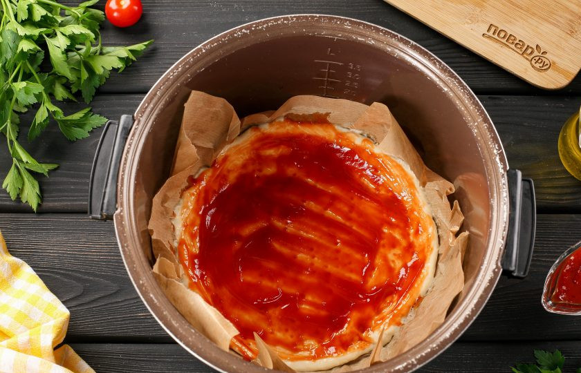 1. Этап. Пицца с сыром в мультиварке: Смажьте тесто соусом.