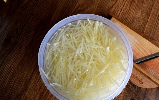 1. Этап. Камди-ча: Картофель очистите, поместите в воду. Нарежьте на терке для корейской морковки. Трите сразу в холодную воду с добавлением уксуса. Отставьте на время. В такой воде картофель не потемнеет, избавится от лишнего крахмала и потом не разварится в кипятке. Тем временем поставьте кастрюлю с водой на огонь и доведите до кипения.