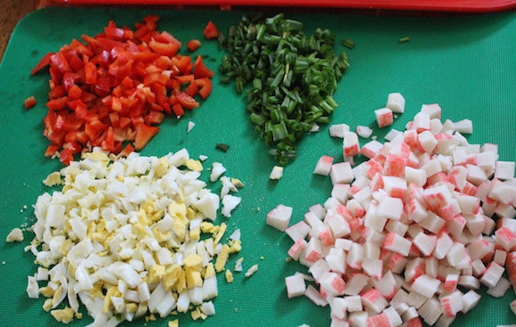 1. Этап. Салат из крабовых палочек с кукурузой: Мелко нарежьте яйца вместе с перцем, луком и крабовыми палочками.