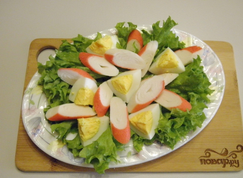 1. Этап. Салат с брокколи и крабовыми палочками: На порционную тарелочку уложите сначала листья салата, а сверху — яйцо и крабовые палочки.