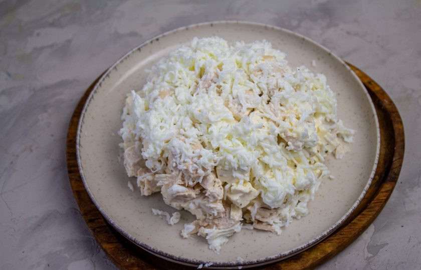 1. Этап. Салат Снежная горка: Поверх салата аккуратно натрите яичные белки, имитируя хлопья снега. Уберите салат в холодильник на пару часов пропитаться.