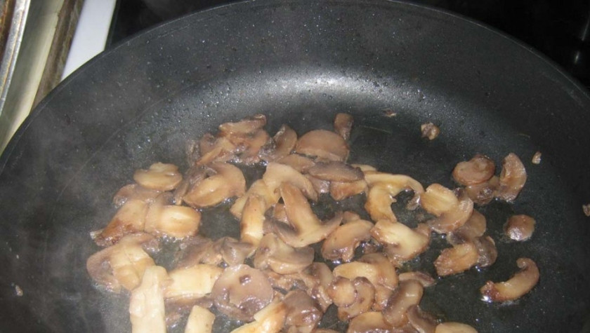 1. Этап. Мясные пальчики: Грибы вымойте и очистите. В сковороду налейте немного растительного масла без запаха и хорошенько его разогрейте. Порежьте шампиньоны на мелкие кусочки или пластинки и обжарьте в масле, чтобы испарился весь лишний сок из них.