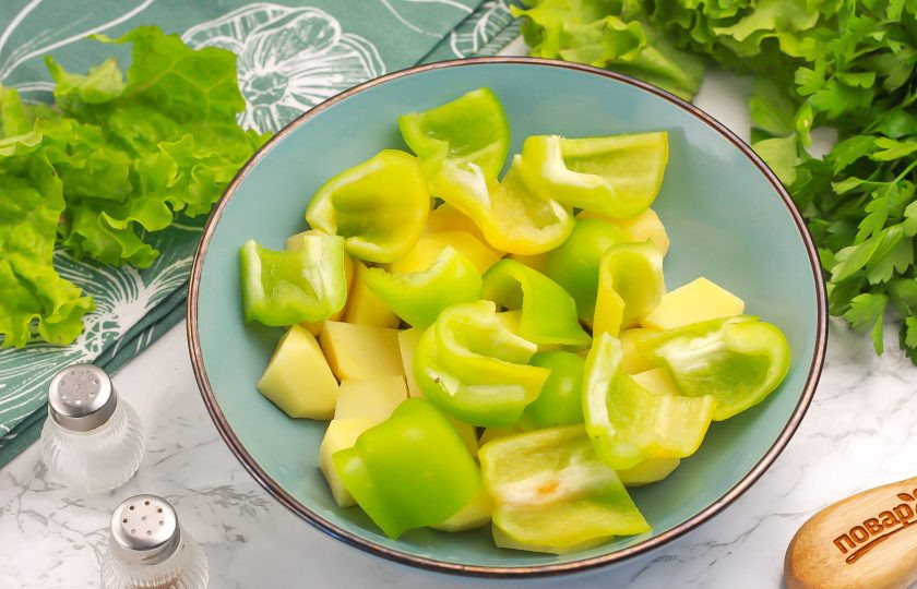 1. Этап. Перец в духовке запеченный с картофелем: Разрежьте болгарские перцы на части и нарежьте четвертинками, добавляя к картофелю.