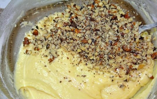 1. Этап. Пирог с яблоками и орехами: Добавьте в тесто половину орехов, снова как следует перемешайте.