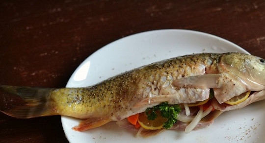 1. Этап. Запекание карпа в духовке: 5. Наполните брюшко смесью овощей, лимона и зелени.