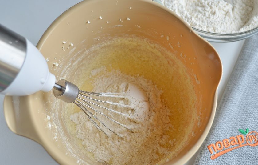 1. Этап. Печенье Елочные игрушки: Небольшими порциями вводите муку. Когда масса станет густой, переходите на стол. Присыпьте его мукой и вывалите тесто, доведите его до готовности.