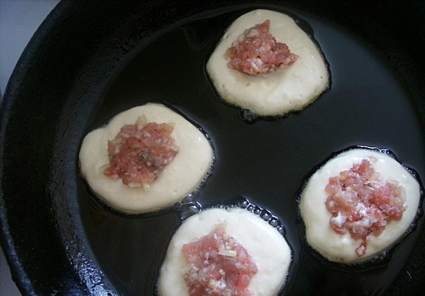 1. Этап. Оладьи с фаршем: Сковородку с подсолнечным маслом хорошо разогреть, ложкой выложить тесто в виде небольших оладий, на каждую из них положить по чайной ложечке фарша.