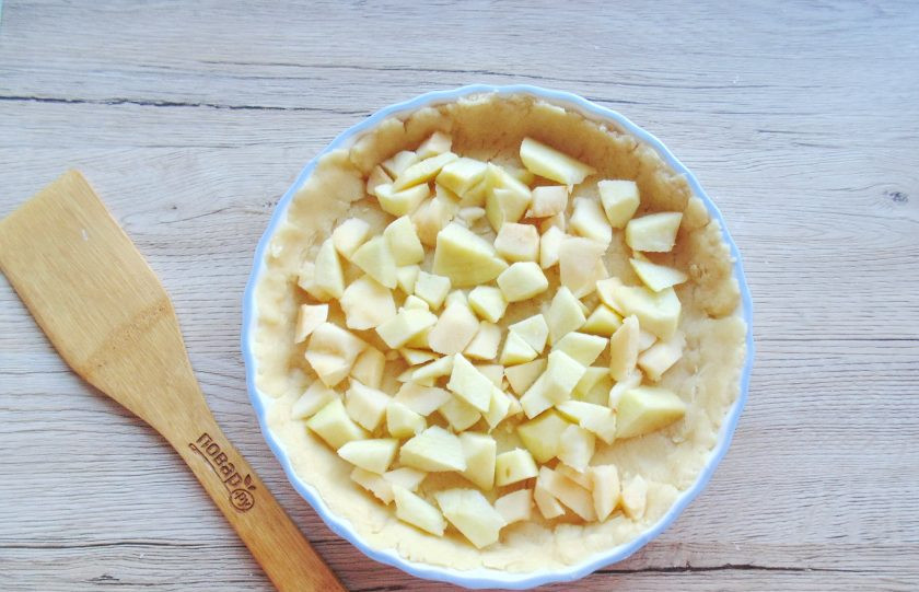 1. Этап. Песочный пирог с яблоками и заварным кремом: Яблоки помойте, очистите, удалите сердцевину и мелко нарежьте. Выложите на тесто.