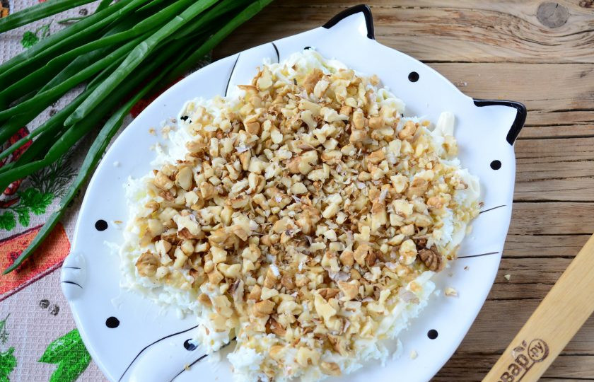 1. Этап. Салат Желтая собака: Орехи измельчите в блендере до состояния крошки или просто порубите широким ножом. Выложите орехи вторым слоем.