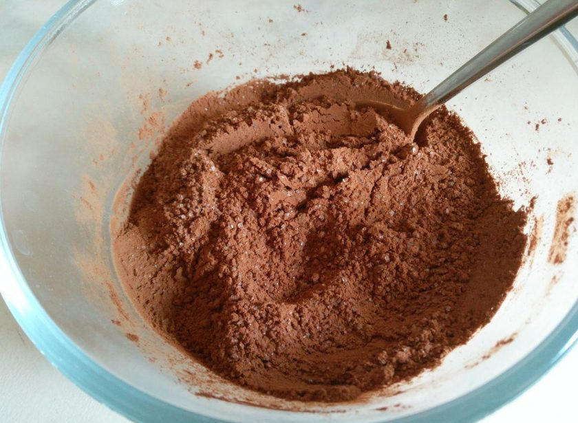 1. Этап. Пирожные Ламингтон, ароматизированные цедрой апельсина: Отдельно смешайте какао-порошок и сахарный песок (50 г). Снимите масляно-молочную смесь с огня, введите в неё сухие компоненты, тщательно перемешивая до однородности.