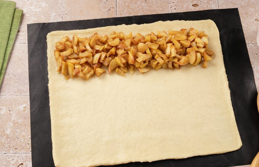1. Этап. Пирог на дрожжах с яблоками: Тесто раскатайте в форме прямоугольника. На край выложите начинку.