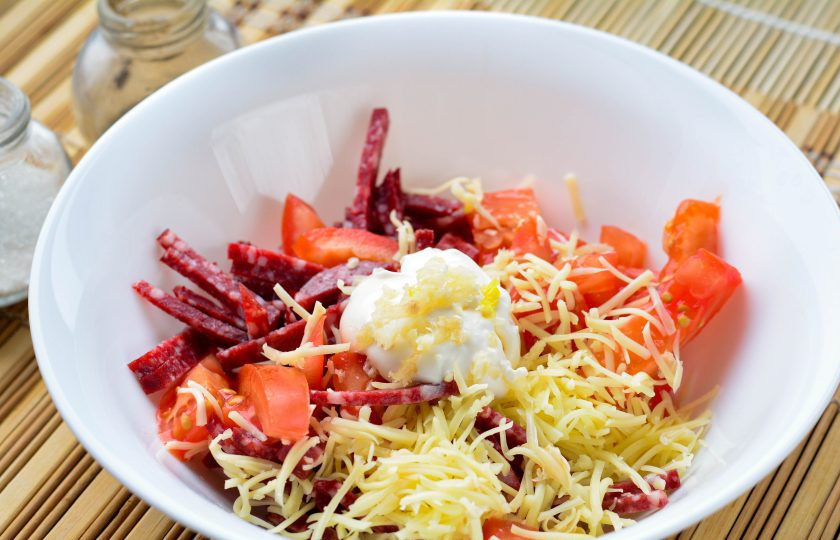 1. Этап. Грузинский салат с колбасой и помидорами: Выдавите чеснок через пресс и добавьте майонез. Салат перемешайте, добавьте соль и перец по вкусу.