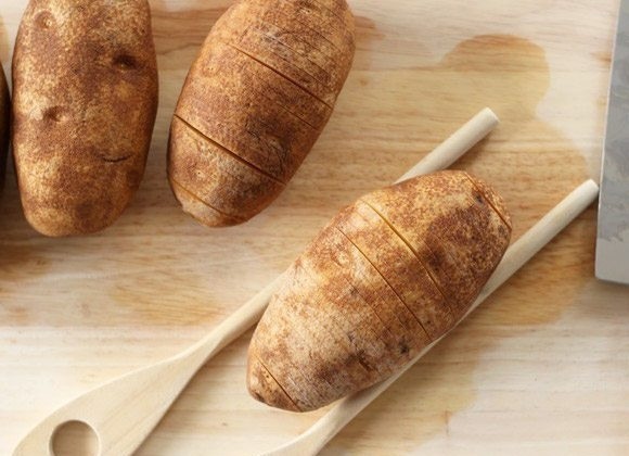 1. Этап. Картошка-гармошка с пепперони: 1. Вымойте картофель, затем с помощью двух лопаток, а точнее их ручек зажмите каждый. Острым ножом сделайте глубокие надрезы, но не дорезайте до самого конца.