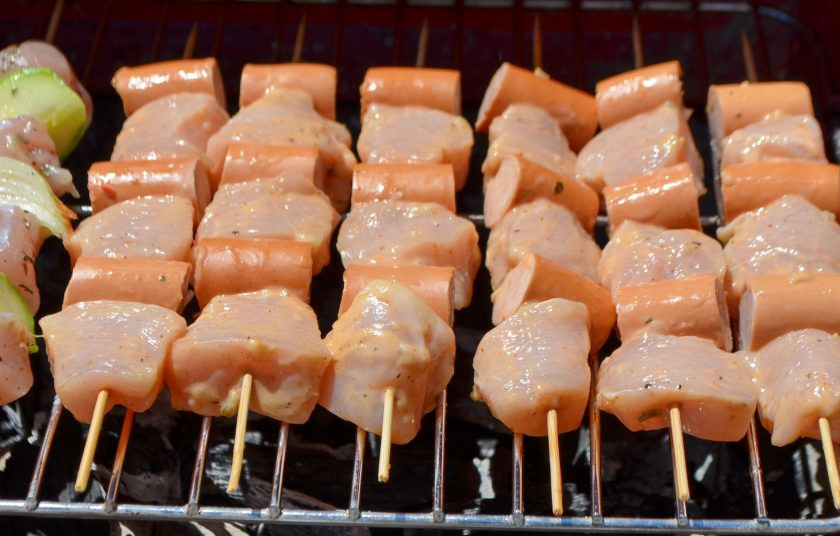 1. Этап. Шашлык из курицы с сосисками: Сосиски порежьте на три части. Нанижите на бамбуковые шампуры куриное филе, чередуя с сосисками.