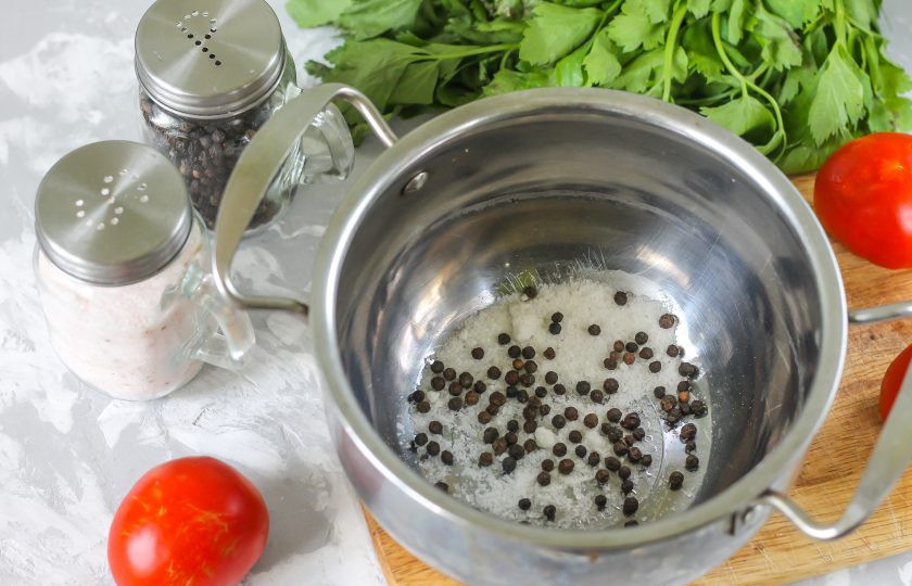 1. Этап. Помидоры с черносливом: В кастрюлю или ковш всыпьте соль и горошины черного перца. По желанию, можете добавить 1 ч.л. сахарного песка, если сливы кисловатые на вкус.