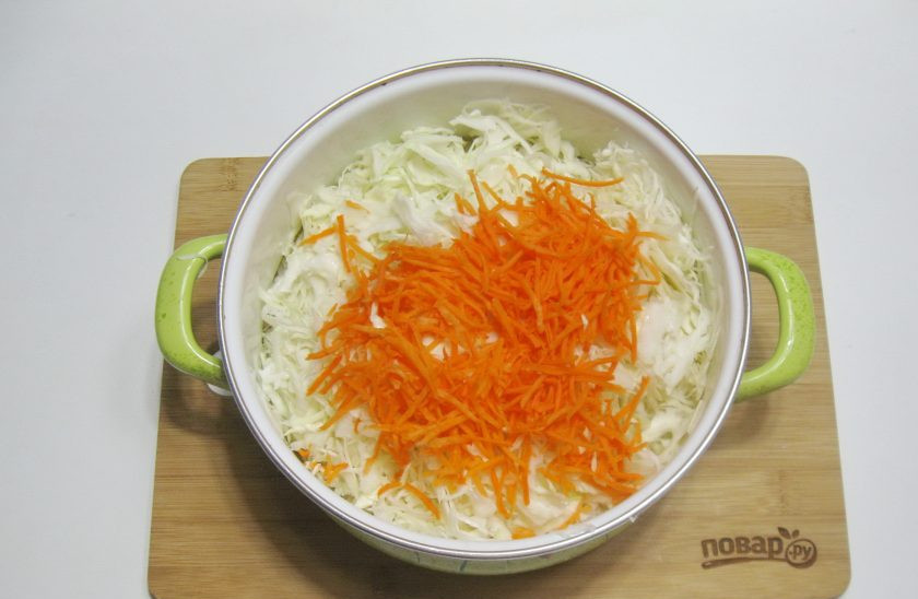 1. Этап. Квашеная капуста с брусникой: Морковь очистите, помойте и натрите на терке. Добавьте к капусте.