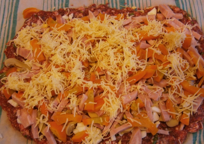 1. Этап. Мясной рулет из лосятины: Вареную морковь нарезаем кубиками. Также кубиками режем ветчину. Присыпаем фарш морковью и ветчиной, добавляем шампиньоны. Сверху трем половину сыра.