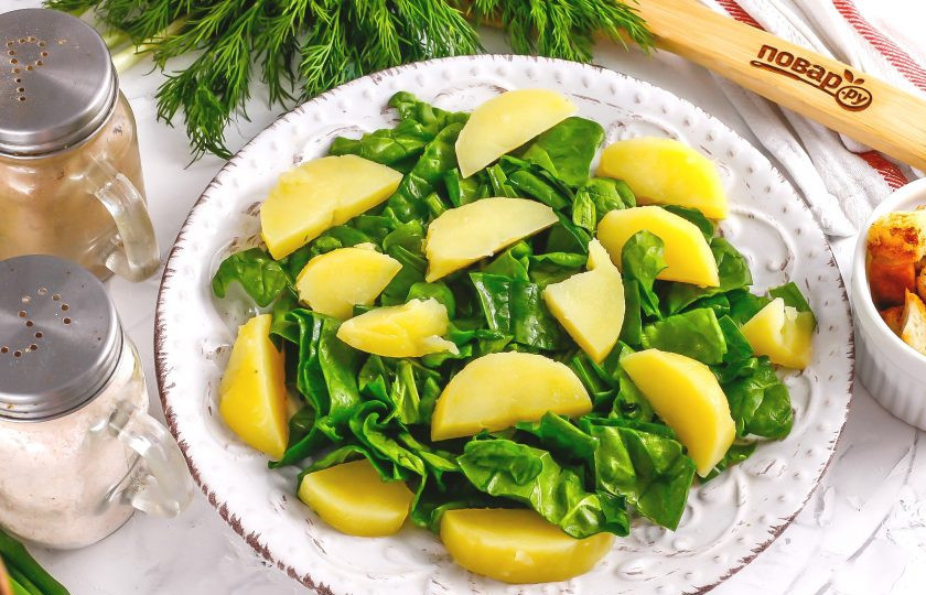 1. Этап. Салат с тунцом и сухариками: Очистите от кожуры картофель, промойте и нарежьте ломтиками. Выложите на шпинат.