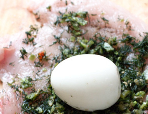 1. Этап. Биточки из куриной грудки: Куски мяса посолите, поперчите, посыпьте зеленью и положите по одному очищенному яйцу.